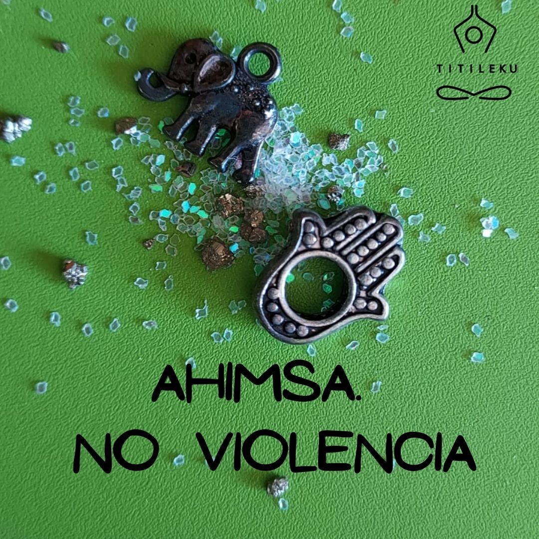 Una fotografía de una mano de Fátima y un elefante de buda con cristalitos cuyo texto dice "Ahimsa. No violencia. Titileku"