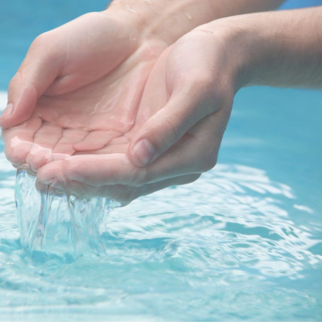 manos en cuenco con agua y deslizando el agua hacia abajo