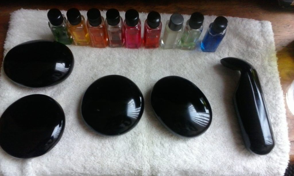 piedras de obsidiana y frascos con esencias sobre una toalla blanca