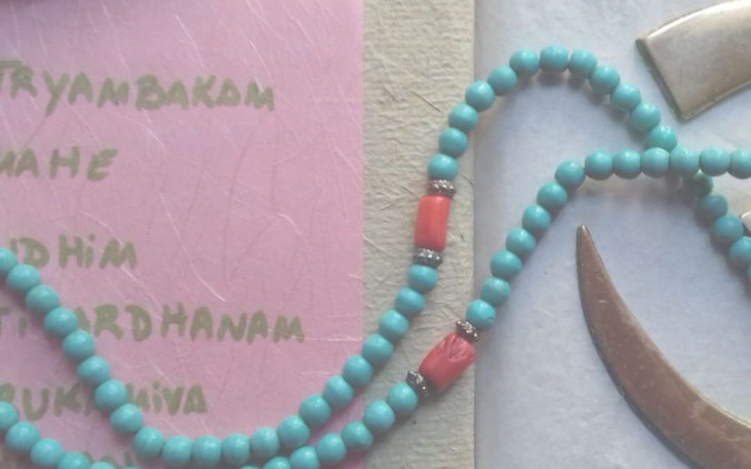 imagen con un mala de meditación, texto con mantra y logo de titileku
